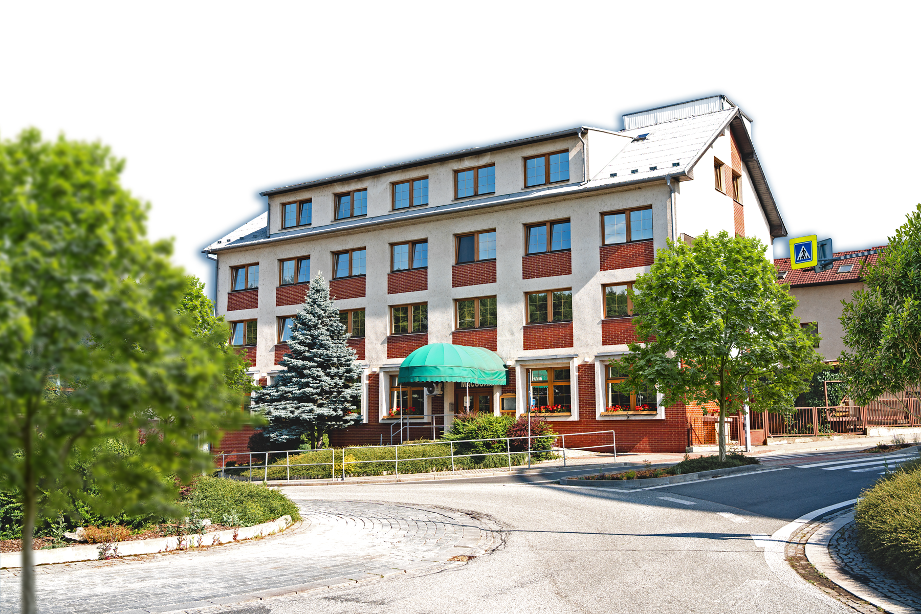 Multi-story hotel building with red brick and white walls, a green dome entrance canopy, surrounded by trees and a curved road in front.
